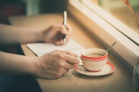 Writing on notebook with coffee cup Stock Photos