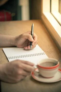 Writing on notebook with coffee cup Stock Photos