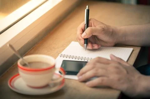 Writing on notebook with coffee cup Stock Photos