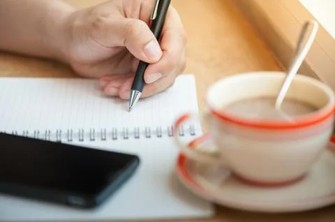Writing on notebook with coffee cup Stock Photos