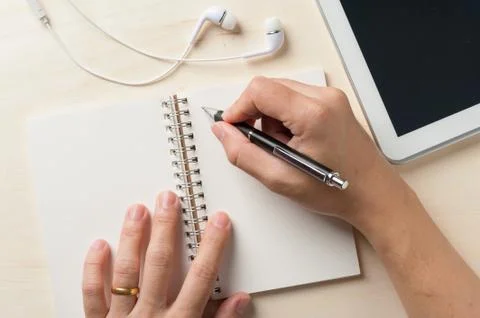 Writing on notebook with small tablet Stock Photos