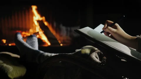 Writing in a notebook while sitting by the fireplace. Plans for the new year Stock Footage 136226537