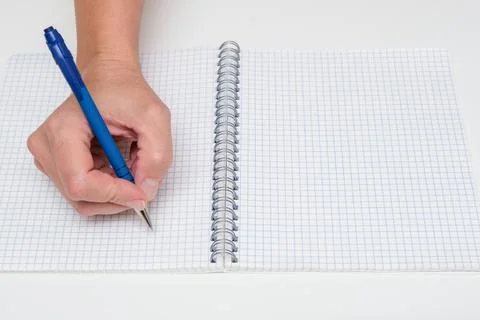 Writing notes or planning a schedule on blank spiral notebook, hand using a pen Stock Photos