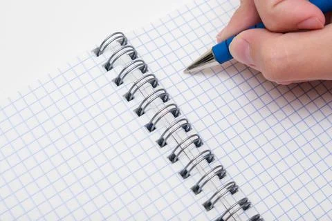 Writing notes or planning a schedule on blank spiral notebook, hand using a pen Stock Photos