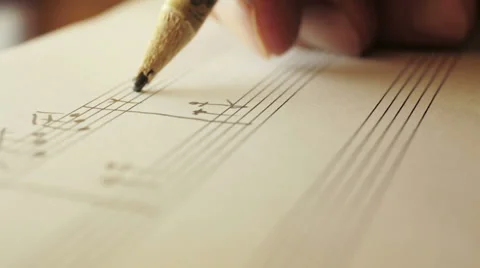 Writing notes on staff: musician is composing with pencil Stock Footage