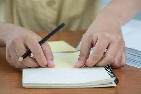 Writing notes in a study space hands holding a pencil a notepad indoor focu.. Stock Photos