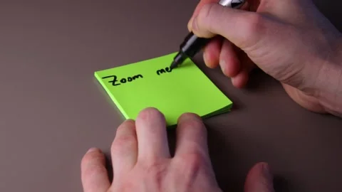 Writing on a post-it note "Zoom meeting next week" Stock Footage 147138358