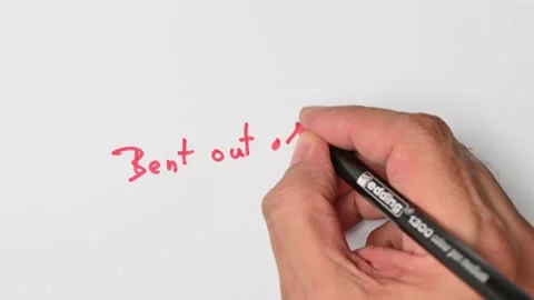 Writing with a red marker the sentence: Bent out of shape Stock Footage 221782438