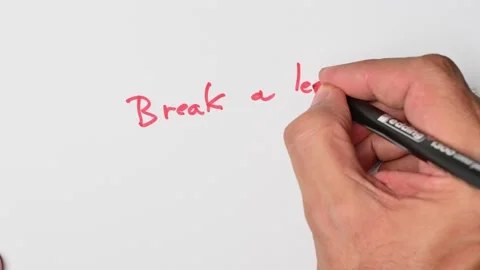 Writing with a red marker the sentence: Break a leg Stock Footage 221783028