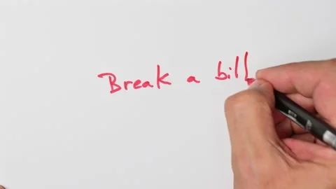 Writing with a red marker the sentence: Break a bill Stock Footage 221783862