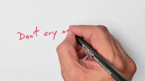 Writing with a red marker the sentence: Don’t cry over spilt milk Stock Footage 221783485