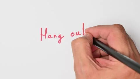 Writing with a red marker the sentence: Hang out Stock Footage 221782053