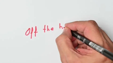Writing with a red marker the sentence: Off the hinge Stock Footage 221782708