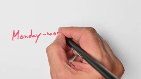 Writing with a red marker the sentence: Monday-morning quarterback Stock Footage 221783486