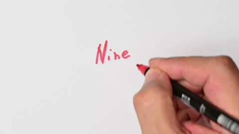 Writing with a red marker the sentence: Nine Stock Footage 221784015