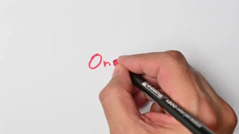 Writing with a red marker the sentence: One Stock Footage 221783857