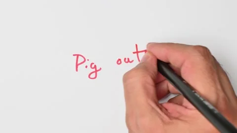 Writing with a red marker the sentence: Pig out Stock Footage 221782067