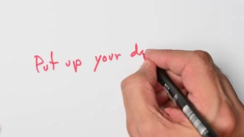 Writing with a red marker the sentence: Put up your dukes Stock Footage 221783480