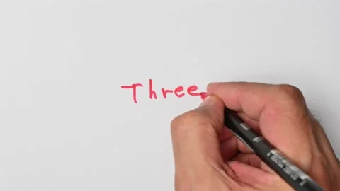 Writing with a red marker the sentence: Three Stock Footage 221783977