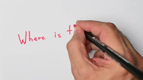 Writing with a red marker the sentence: Where is the bathroom Stock Footage 221781248