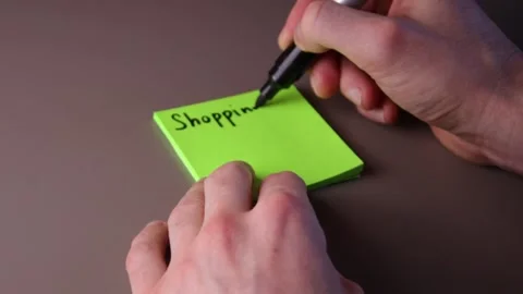 Writing shopping list on a post-it note Stock Footage 147138274