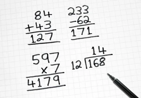 Writing simple maths sums on square paper. Stock Photos