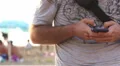 Writing on a smartphone (with beach on background) HD Footage