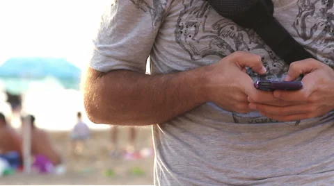 Writing on a smartphone (with beach on background) Stock Footage 36534891