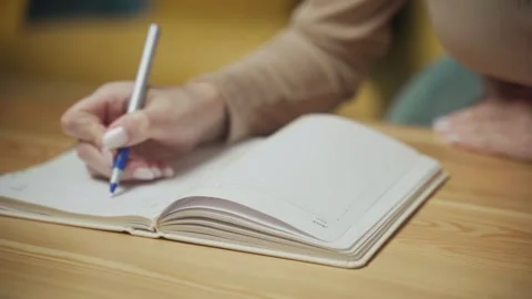 Writing thoughts and ideas in a personal notebook during quiet moments at home Vídeo Stock 303768063