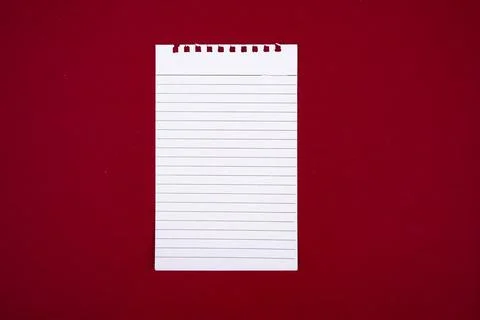 Writing tools, an open notebook page on a red background. Foto stock
