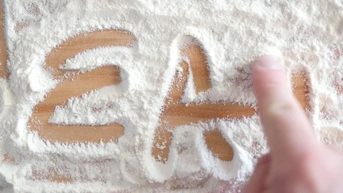 Writing word eat on table full of flour Stock Footage 88411906