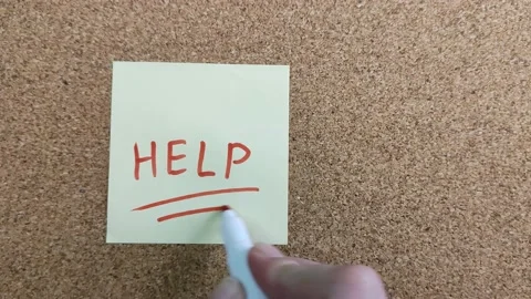 Writing the word HELP with a red felt-tip pen on a yellow paper sticker. Stock Footage 170087580