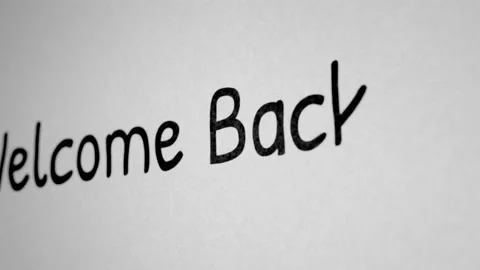 Writing the word Welcome Back, drawing with black marker on white paper Stock Footage 161493546