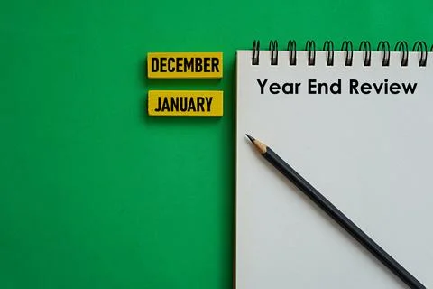 Written note YEAR END REVIEW and printed wooden block DECEMBER JANUARY Fotos de archivo