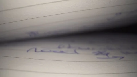 Written text in notebook closeup macro sliding through in slowmotion Stock Footage
