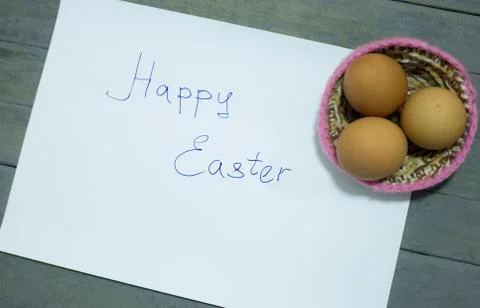 Written the word:happy easter with three eggs and nest. Stock Photos