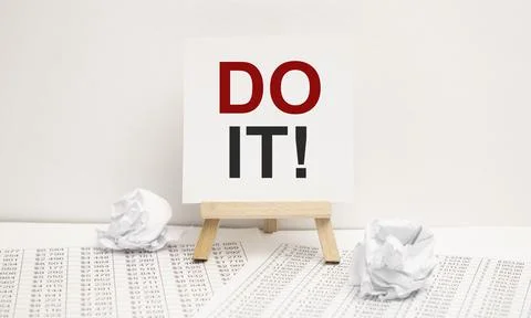 Written words do it on paper notebook with pen on white background. Stock Photos