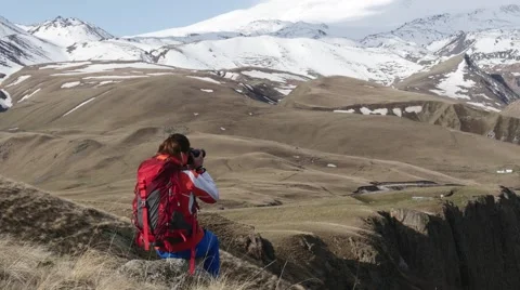 Wrl with the backpack on the stone and with the camera Stock Footage 63365654