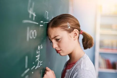 This is wrong. a stressed young elementary school kid writing answers to math Stock Photos