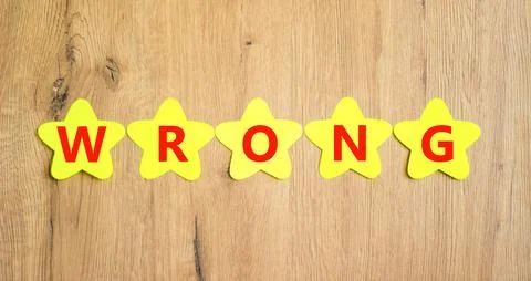 Wrong symbol. Concept word Wrong on beautiful yellow paper stars. Beautiful.. Stock Photos