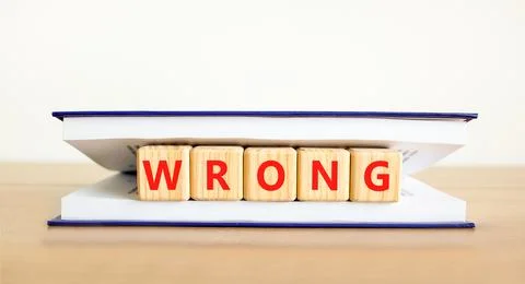 Wrong symbol. Concept word Wrong on beautiful wooden blocks in book. Beautifu Stock Photos