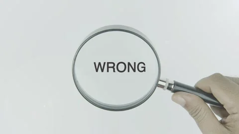 Wrong text or word highlighted by a magnifying glass in a hand on a white Stock Footage 303738033