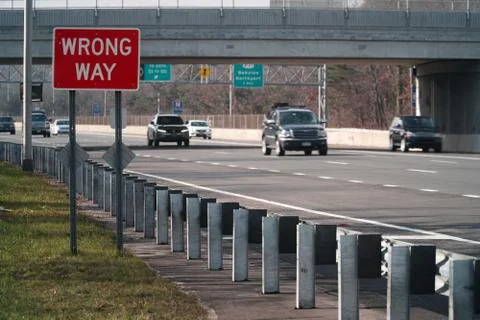 Wrong Way caution safety sign posted along a major interstate highway Stock Photos