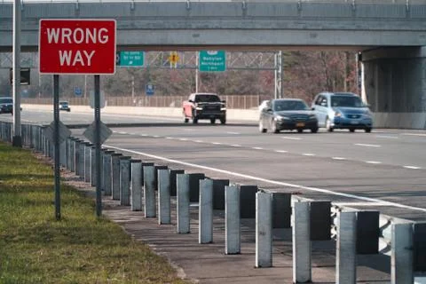 Wrong Way caution safety sign posted along a major interstate highway Stock Photos