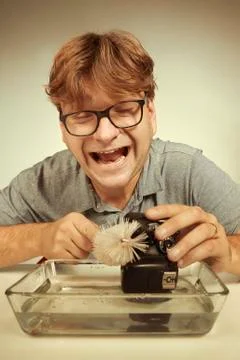 Wrong way cleaning sensor of digital camera by service man in water Stock Photos