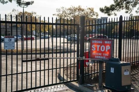 Wrong way stop severe tire damage notice in front of gated parking lot Stock Photos