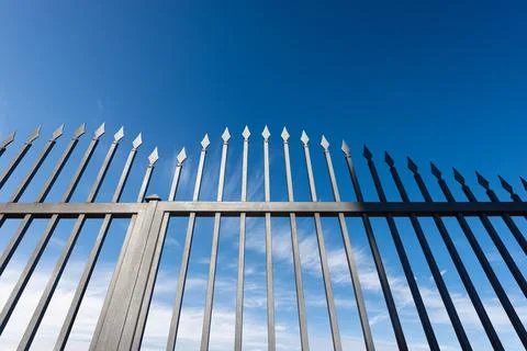 Wrought Iron Gate with Sharp Points on Blue Sky with Clouds Stock Photos