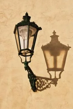 Wrought-iron lantern with its shadow on the yellow wall, Prague, Stock Photos
