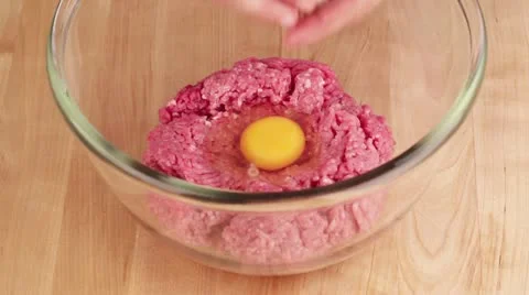 Wrung out softened bread being added to minced meat and an egg Stock Footage 24671839