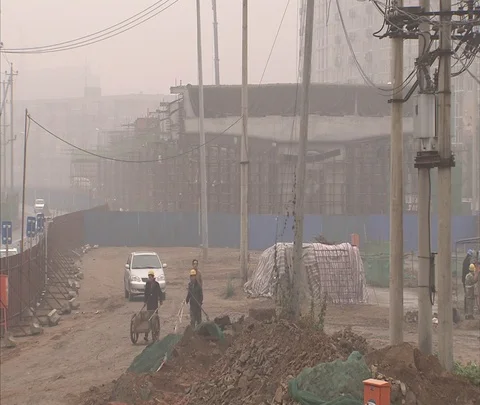 WS construction site, workers in hard hats push cart of iron bars Stock Footage 86744217